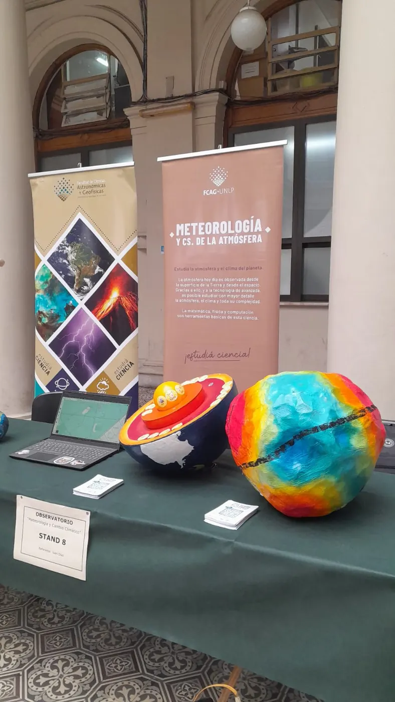 Mesa de la muestra con globos terráqueos y material sobre meteorología y climatología.
