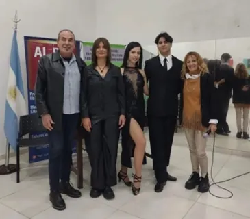 Bailarines y organizadores posan junto a la bandera argentina después de una muestra de tango.