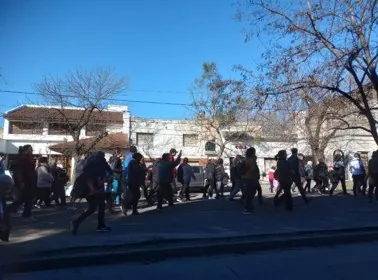 Caminantes avanzan por una calle arbolada durante una correcaminata solidaria.