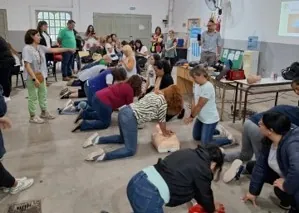 Vecinos practican reanimación cardiopulmonar sobre muñecos en un taller de RCP.