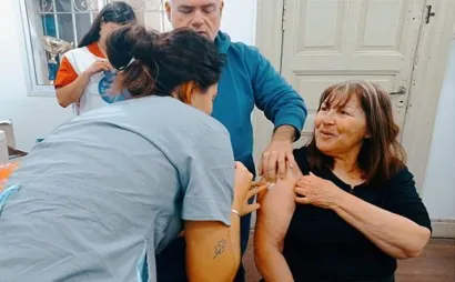 Una vecina recibe una vacuna en el brazo durante una campaña de salud.