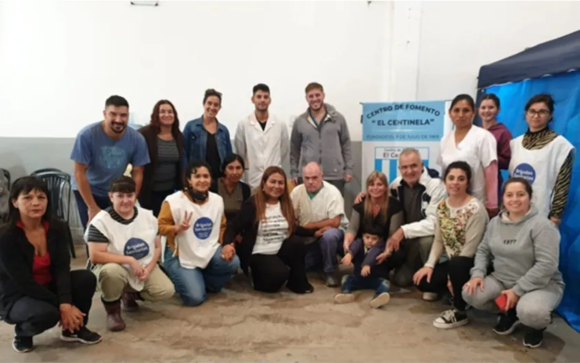 Equipo de salud y voluntarios posan con remeras de la campaña en el Centro de Fomento El Centinela.